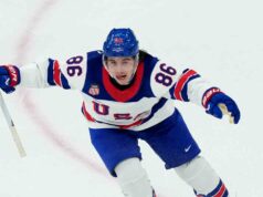 Jack Hughes degli Stati Uniti osserva il disco olimpico da gol della Hockey Corridor of Fame