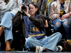 Caitlin Clark lavora con la telecamera a bordo campo durante la serata dei 43 punti di Luka Doncic contro i Pacers