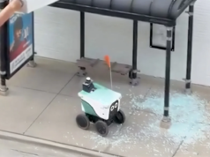 Il robotic di consegna autodiretto si dirige direttamente attraverso una pensilina dell’autobus